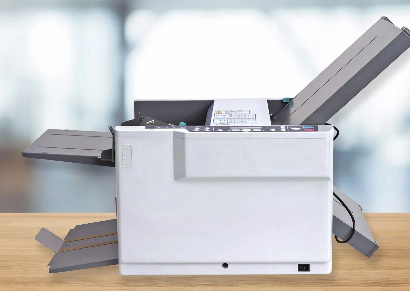 FP DF870c automatic tabletop folder on a desk with its fold plates and output tray extended
